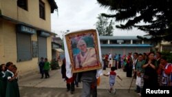 FILE - A Tibetan man carries a portrait of Dalai Lama during a function organized to mark the 82nd birthday celebration of Dalai Lama in Lalitpur, Nepal, July 6, 2017. 