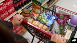 FILE - A customer shops for groceries at a supermarket in Bellflower, Calif., on Feb. 13, 2023. 