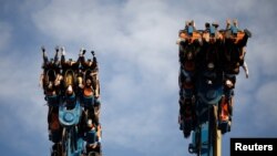 People wearing face masks enjoy the attraction while visiting the Happy Valley amusement park, following an outbreak of the coronavirus disease (COVID-19), in Beijing, China May 10, 2020. 