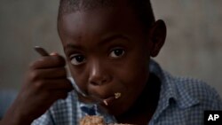 Un estudiante come en una escuela usada como centro de distribución del Programa Mundial de Alimentos en Chauffard, Haití. Una evaluación en octubre reveló que más de 1 millón de personas sufren grave escasez de alimentos en Haití.