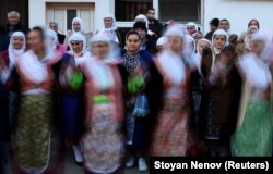 Muslimah Bulgaria menyaksikan para tamu menari di upacara pernikahan Kimile Avdinova dan pengantin prianya Kadri Kichukov di Desa Ribnovo, di Pegunungan Rhodope, Bulgaria, 2 Januari 2022. (Foto: REUTERS/Stoyan Nenov)