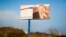 FILE - A partially damaged billboard with a portrait of Russian President Vladimir Putin is seen on a roadside near Simferopol, Crimea, Jan. 24, 2016. The billboard reads: "Crimea. Russia. Forever."