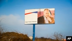 ປ້າຍໂຄສະນາທີ່ເປ່ເພສ່ວນໜຶ່ງເຊິ່ງມີຮູບຂອງປະທານທາທິບໍດີ ຂອງ ຣັດເຊຍ ທ່ານ Vladimir Putin ສາມາດແນມເຫັນໄດ້
ຈາກຂ້າງທາງໃກ້ກັບເມືອງ Simferopol, ແຫຼມ Crimea. 24 ມັງກອນ, 2016.