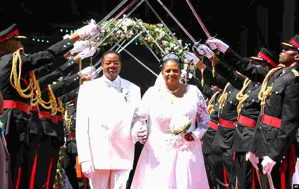 President Bingu wa Mutharika and his Bride Callista walk under a military sword salute by officers of the Malawian defense forces after their wedding ceremony at Civo stadium in Lilongwe, April 17, 2010. (AFP Photo)