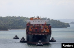 Sebuah kapal kargo sedang ditarik oleh sejumlah kapal tunda melewati Terusan Panama menuju laut lepas di Aqua Clara, di pinggiran kota Colon City, Panama, 20 Januari 2024. (Foto: Roberto Cisneros/Reuters)