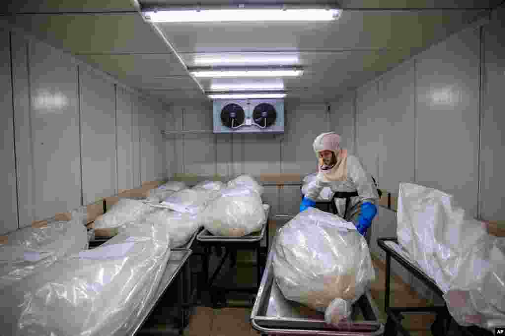 A worker from &quot;Hevra Kadisha,&quot; Israel&#39;s official Jewish burial society, prepares bodies before a funeral procession at a special morgue for COVID-19 victims,&#160;in the central Israeli city of Holon, near Tel Aviv.