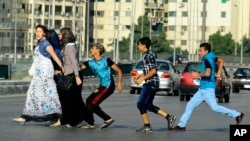 FILE - In this Aug. 20, 2012 file photo, an Egyptian youth, trailed by his friends, gropes a woman crossing the street with her friends in Cairo, Egypt. (AP Photo/Ahmed Abd El Latif, El Shorouk Newspaper, File)