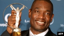  L'ancien basketteur américain Dikembe Mutombo pose avec son prix « Sport for Good » pour son action caritative au Congo.