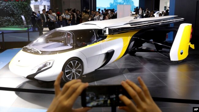 A visitor takes a photo of the Aeromobil, a flying car from Slovakia, during the China International Import Expo in Shanghai, Nov. 5, 2018. 
