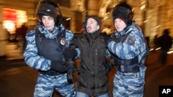 FILE - Police officers detain a protester during an unsanctioned protest in Moscow, Russia, Dec. 30, 2014.