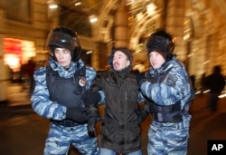 FILE - Police officers detain a protester during an unsanctioned protest in Moscow, Russia, Dec. 30, 2014.