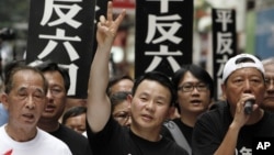 FILE - Xiong Yan flashes a victory sign during a march in Hong Kong marking the 20th anniversary of the military crackdown on a pro-democracy student movement in Beijing, May 31, 2009. 