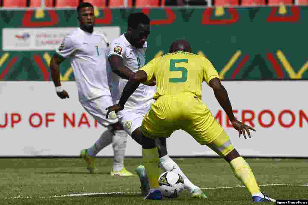 Senegal&#39;s forward Boulaye Dia (C) fights for the ball with Zimbabwe&#39;s defender Gerald Takwara (R).