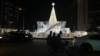 FILE - A man rides a motorcycle taxi past Christmas decorations on a street in Lagos, Nigeria, Dec. 20, 2024. 