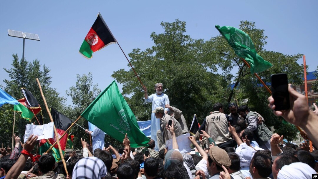 Capres Afghanistan Abdullah Abdullah (tengah) memegang bendera Afghanistan dalam aksi protes menentang hasil pemilu di Kabul, Afghanistan, Jumat (27/6).