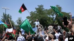 Capres Afghanistan Abdullah Abdullah (tengah) memegang bendera Afghanistan dalam aksi protes menentang hasil pemilu di Kabul, Afghanistan, Jumat (27/6).