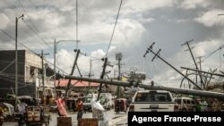 Fallen electric pylons block a road in Surigao City, Surigao del norte province, days after super Typhoon Rai devastated the city.