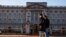 People wearing face masks walk past Buckingham Palace amid the COVID-19 outbreak, in London, Britain, Jan. 22, 2021.