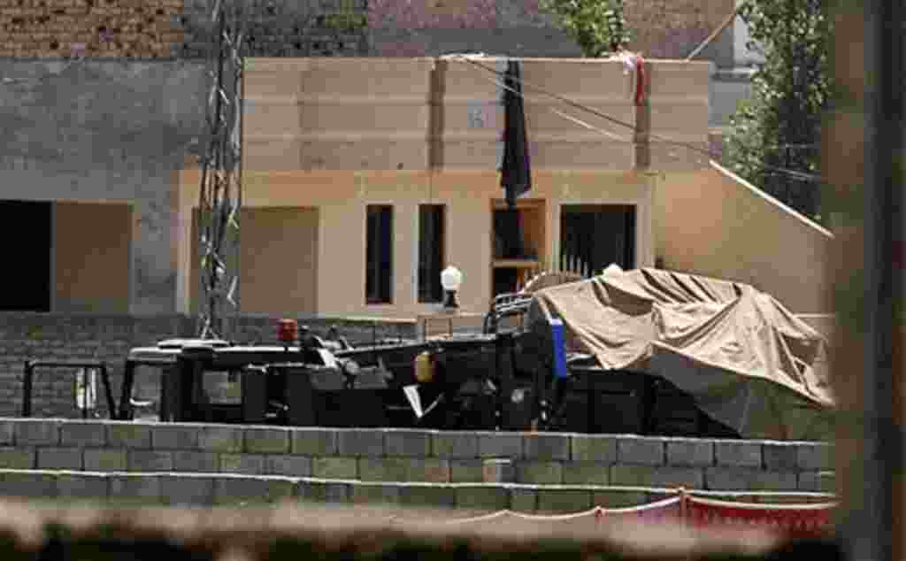 Vehicles are parked inside the compound of a house where it is believed al-Qaida leader Osama bin Laden lived in Abbottabad, Pakistan on Monday, May 2, 2011. Bin Laden, the glowering mastermind behind the Sept. 11, 2001, terror attacks that killed thousa