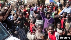 Internally displaced people celebrate during a distribution of tarps in Mubimbi, South Kivu, Democratic Republic of Congo, March 4, 2013.