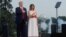 U.S. President Donald Trump and first lady Melania Trump hold their hands over their hearts for the U.S. National Anthem as military artillery fires off a salute on the Ellipse with the Jefferson Memorial in the background during a 4th of July "2020 Salut