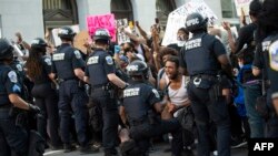 A man screams with emotion as he sees a policeman take a knee 