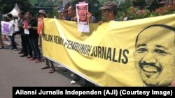 Poster jurnalis yang terbunuh saat menjalankan tugas, Prabangsa, serta tuntutan pencabutan remisi oleh Presiden digelar jurnalis dari AJI se-Jawa Timur, Surabaya, 9 Februari 2019. (Foto: Aliansi Jurnalis Indonesia)