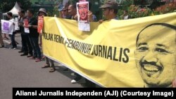 Poster jurnalis yang terbunuh saat menjalankan tugas, Prabangsa, serta tuntutan pencabutan remisi oleh Presiden digelar jurnalis dari AJI se-Jawa Timur, Surabaya, 9 Februari 2019. (Foto: Aliansi Jurnalis Indonesia)