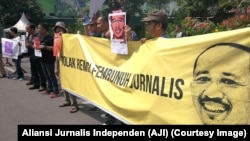 Poster jurnalis yang terbunuh saat menjalankan tugas, Prabangsa, serta tuntutan pencabutan remisi oleh Presiden digelar jurnalis dari AJI se-Jawa Timur, Surabaya, 9 Februari 2019. (Foto: Aliansi Jurnalis Indonesia)