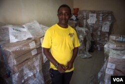 Andrew Raka, electoral officer in charge of Port Loko district, stands in front of some of the ballots which will be used during the election in Port Loko, Sierra Leone, March 10, 2018. (J. Patinkin/VOA)