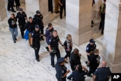 Activistas que se oponen al asediado candidato del Tribunal Supremo del presidente Donald Trump, Brett Kavanaugh, son arrestados en el Capitolio, en Washington, el lunes 24 de septiembre de 2018. (Foto AP / J Scott Applewhite).