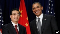 US President Barack Obama greets Chinese President Hu Jintao before the APEC leaders dinner in Honolulu, November 12, 2011.