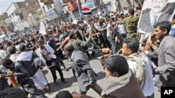 Supporters of the Yemeni government, right, reach to scuffle with anti-government demonstrators celebrating the resignation of Egyptian leader Hosni Mubarak and demanding the ouster of their own president, in Sana'a, Yemen, February 12, 2011