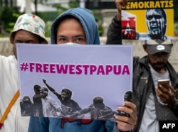 Para aktivis membawa poster-poster saat berdemo untuk menarik perhatian kepada isu HAM Papua, di depan Kedutaan Besar Belanda di Jakarta, di tengah kunjungan Raja Belanda Willem-Alexander, 12 Maret 2020. (Foto: AFP)