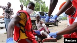 FILE - Paramedics attend to a man injured at the scene of a suicide explosion at a restaurant near a police academy, in Mogadishu, Somalia, Nov. 17, 2020. 