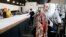 Workers at F.A.B.R.I.C., a non-profit organization, fold a large roll of fabric to make personal protective equipment after converting the fashion design warehouse to make gowns for area Dignity Health employees due to the coronavirus, April 13, 2020.