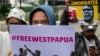 Para aktivis membawa poster-poster saat berdemo untuk menarik perhatian kepada isu HAM Papua, di depan Kedutaan Besar Belanda di Jakarta, di tengah kunjungan Raja Belanda Willem-Alexander, 12 Maret 2020. (Foto: AFP)