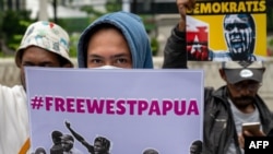 Para aktivis membawa poster-poster saat berdemo untuk menarik perhatian kepada isu HAM Papua, di depan Kedutaan Besar Belanda di Jakarta, di tengah kunjungan Raja Belanda Willem-Alexander, 12 Maret 2020. (Foto: AFP)