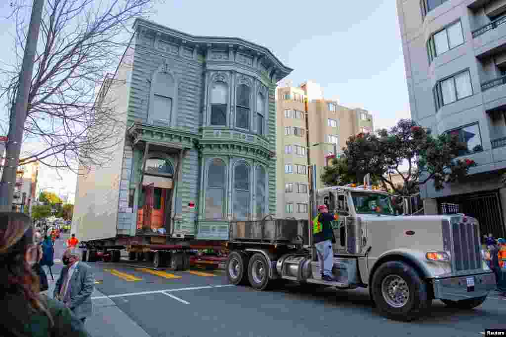 Workers move a 139-year-old Victorian house known as the Englander House to a new location in San Francisco, California, Feb. 21, 2021. A 48-unit, eight-story apartment building will be built at the original site.