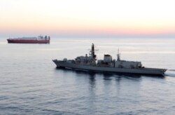 FILE - In this image from file video provided by UK Ministry of Defence, British navy vessel HMS Montrose escorts another ship during a mission to remove chemical weapons from Syria at sea off coast of Cyprus in February 2014.