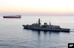 FILE - In this image from file video provided by UK Ministry of Defence, British navy vessel HMS Montrose escorts another ship during a mission to remove chemical weapons from Syria at sea off coast of Cyprus in February 2014.