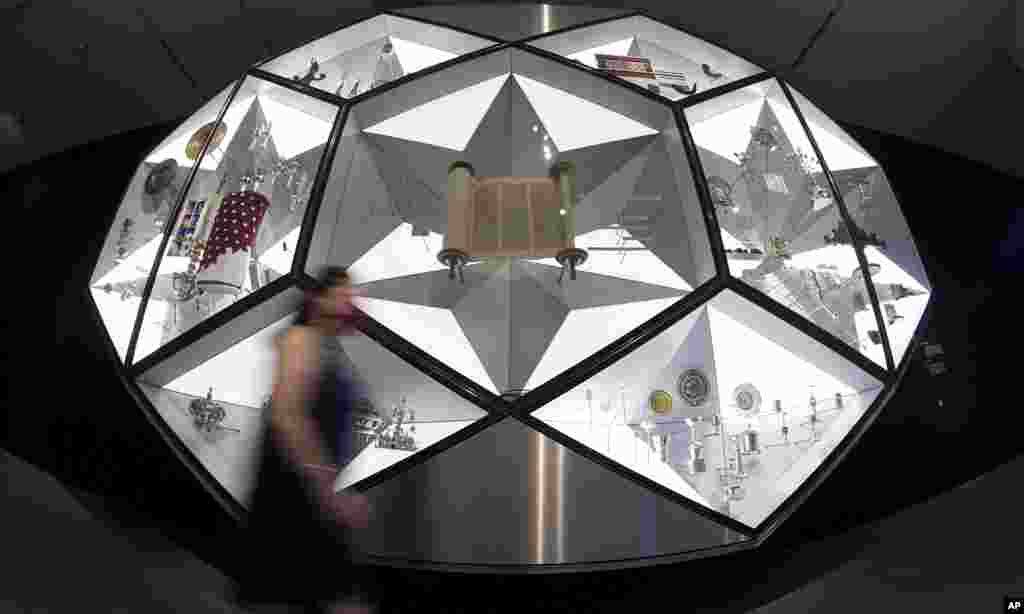 A woman walks past a showcase with a Torah scroll shown in the new show &#39;Jewish Life in Germany: Past and Present&#39; at the Jewish Museum in Berlin, German.