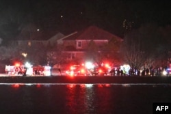 Se ven las luces de los vehículos de emergencia mientras los equipos de rescate se reúnen a lo largo del río Potomac cerca del Aeropuerto Nacional Reagan en Washington, DC, después de un accidente aéreo el 29 de enero de 2025.