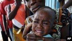 A health worker administers a yellow fever vaccine to a baby on a roadside in Koumassi, a poor area of Abidjan, after a case of yellow fever was discovered (File)