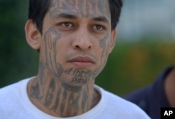 A Barrio 18 gang member is taken in shackles inside the San Salvador Justice Center, July 2, 2018. The Barrio 18 gang, along with the Mara Salvatrucha gang, have working-class neighborhoods divided up like a checkerboard.