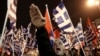 FILE - A supporter of Greece's extreme right Golden Dawn party raises his hand in a Nazi-style salute during a rally in Athens Feb. 1, 2014.