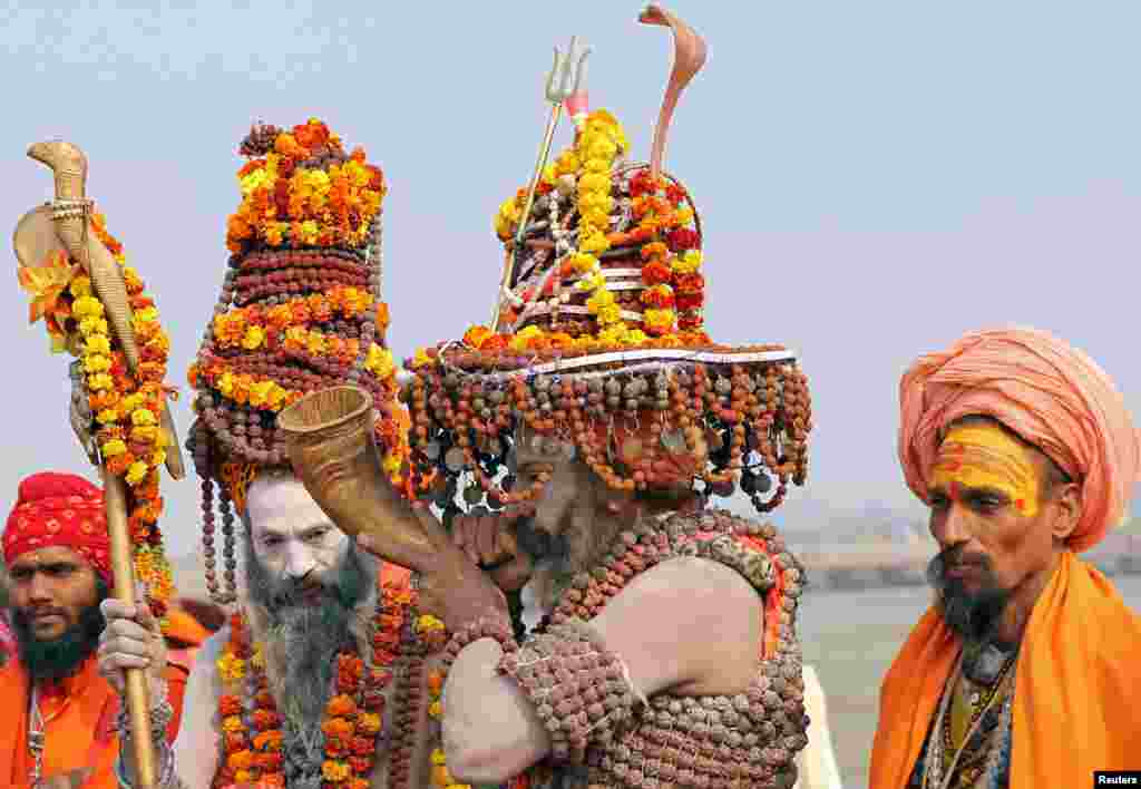 A Naga Sadhu or a Hindu holy man, wearing prayer beads, plays a traditional instrument on the banks of the River Ganges ahead of the "Kumbh Mela," or the Pitcher Festival, in Prayagraj, previously known as Allahabad, India.