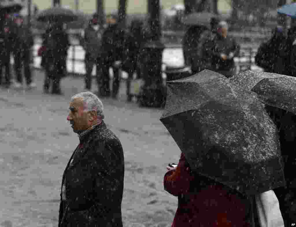 People wait in line to enter a courthouse on a snowy morning in New York, Dec. 10, 2013.