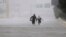 Two people walk down a flooded section of Interstate 610 in floodwaters from Tropical Storm Harvey, Aug. 27, 2017, in Houston, Texas. 