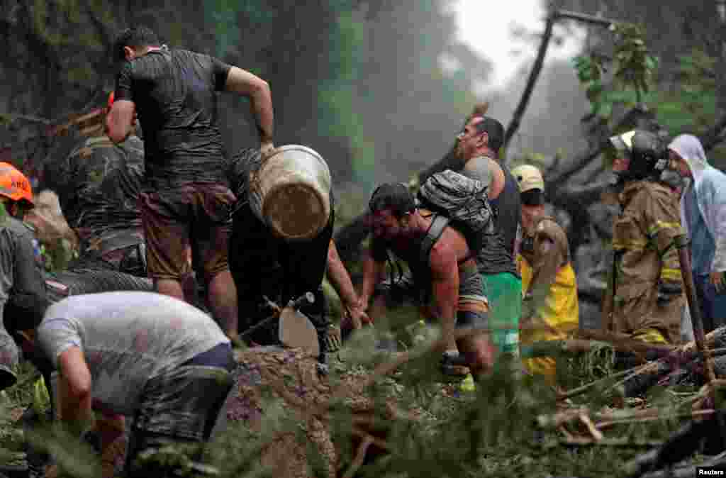 브라질 리우데자네이루에서 폭우가 내린 후 산사태가 발생한 가운데 구조대원들과 시민들이 시신을 수색하고 있다.